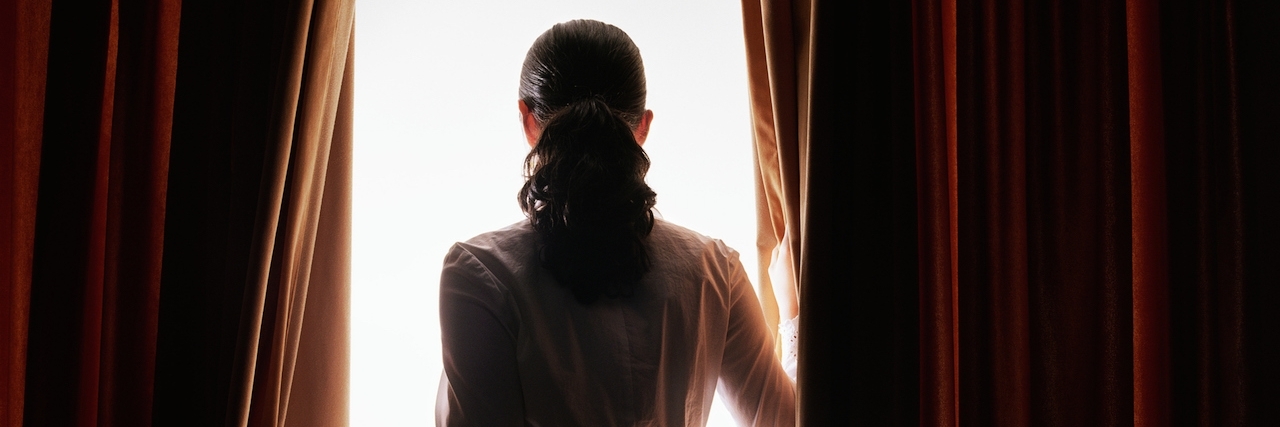 How to Understand a Loved One Who Has OCD Woman staring through curtains