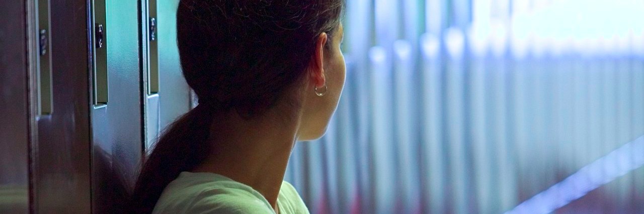 Woman Thanks Friend Who Gave Her Suicide Note to a Counselor Girl standing next to a row of lockers