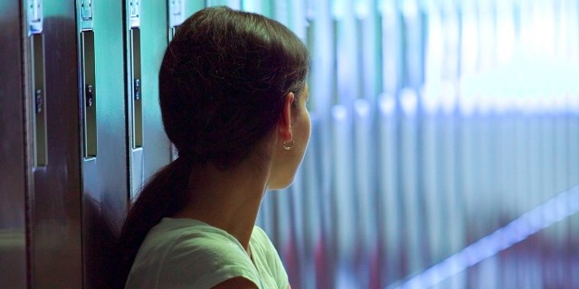 To the Kids Who Think My Daughter Is Faking Her Condition Girl standing next to a row of lockers