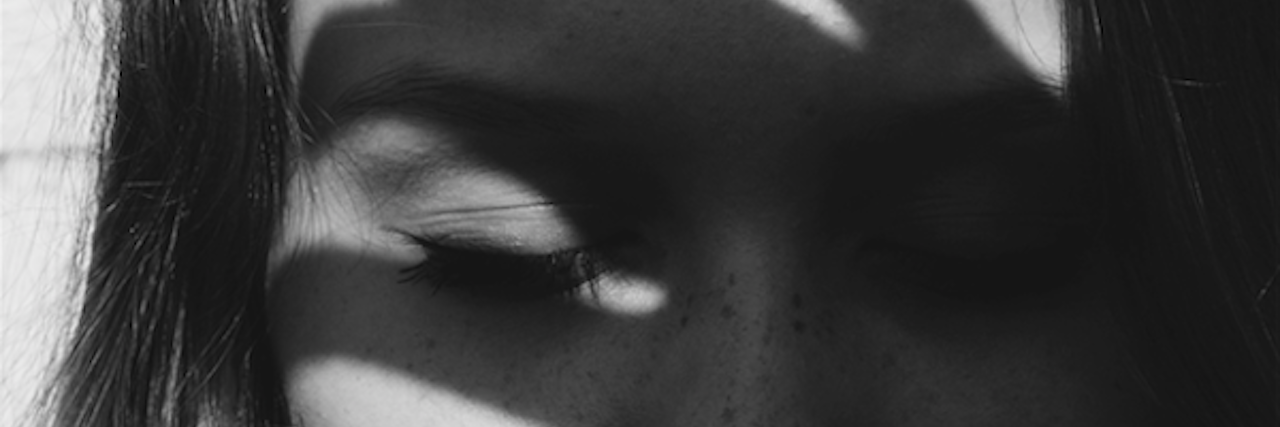 How It Feels: Losing a Friend to Suicide woman with the shadow of a hand over her face