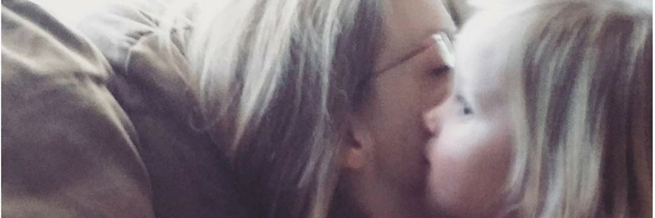 Heartbroken on Mother's Day: Dealing With Grief little girl kissing her mom's cheek on the couch