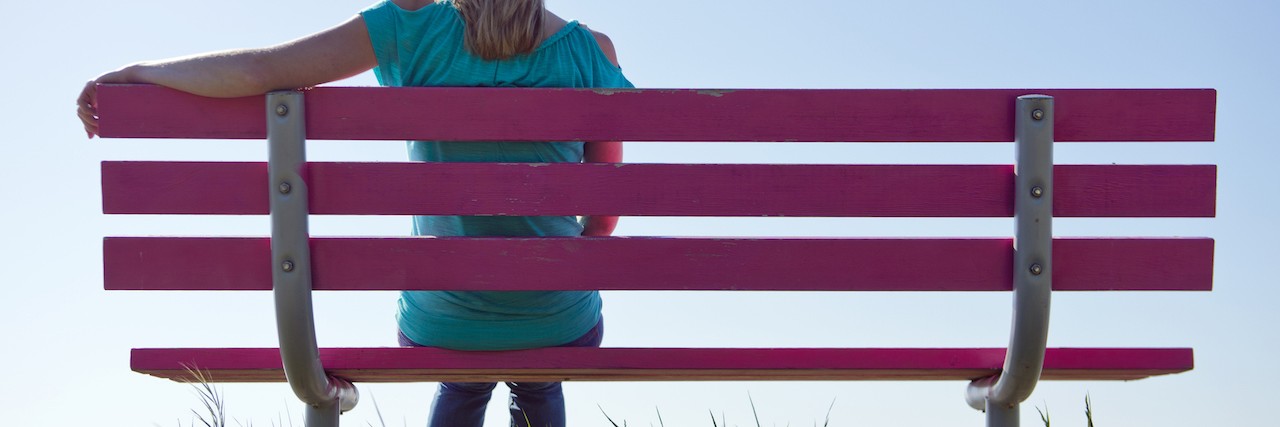 Loneliness and Isolation as Side Effects of Chronic Illness Young, blonde, woman sitting alone on a bench