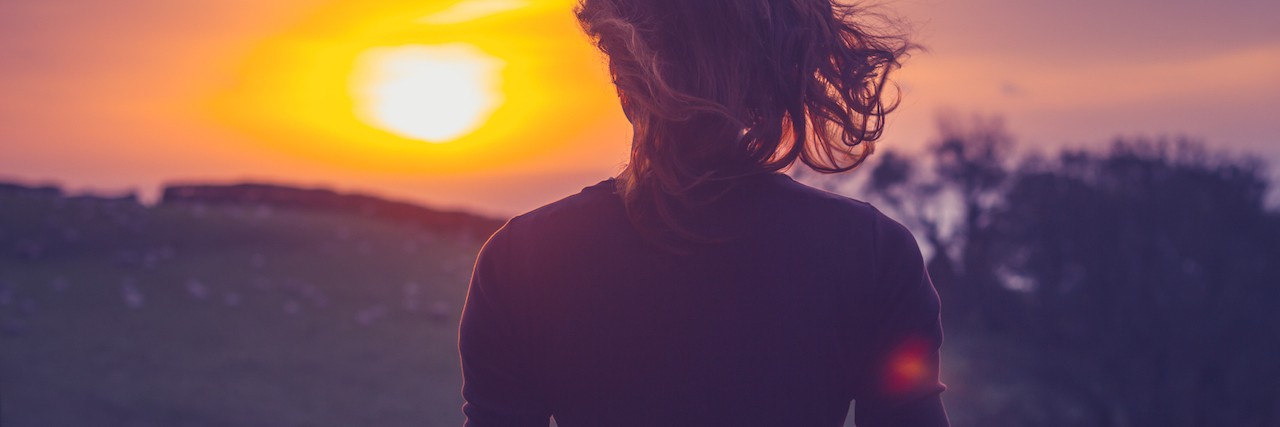 What My Son Taught Me After His Death Rear view of young woman admiring the sunset over a field from her balcony