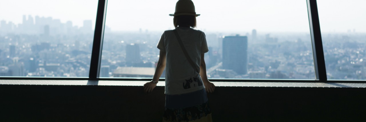 Not Fitting In as a Person on the Autism Spectrum Woman watching Tokyo cityscape from high rise