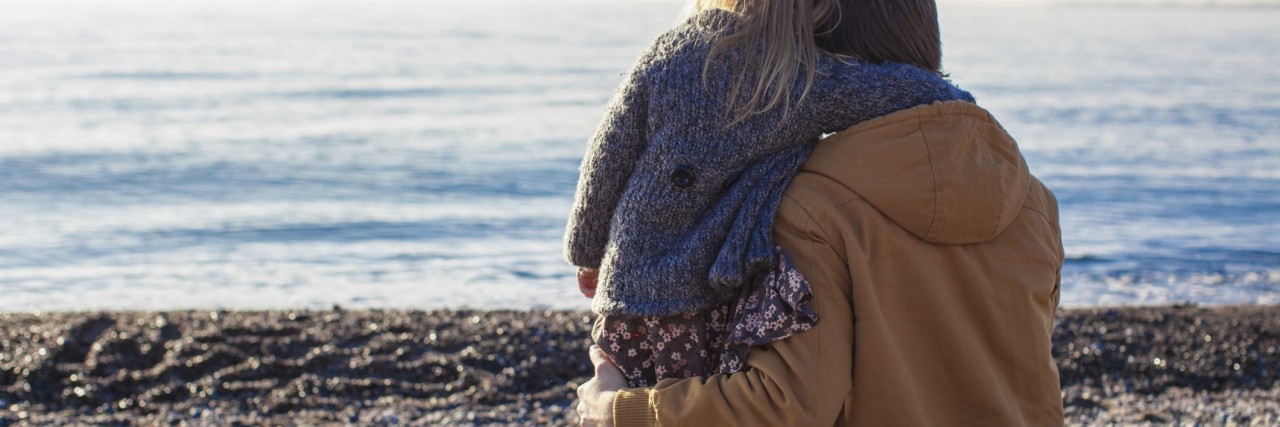 When Parents Don't Accept a Child's Autism Diagnosis Back view of Young father and little girl at beach
