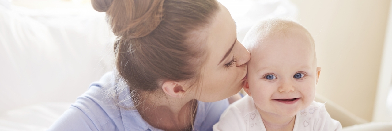Hardest Things About Postpartum Depression Mother kissing her baby