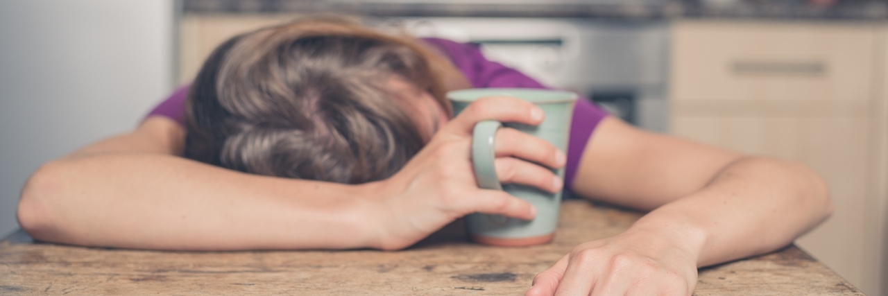 Why the Spoon Theory Doesn't Fit My Life A tired young woman is having a cup of tea and is resting her head on a table