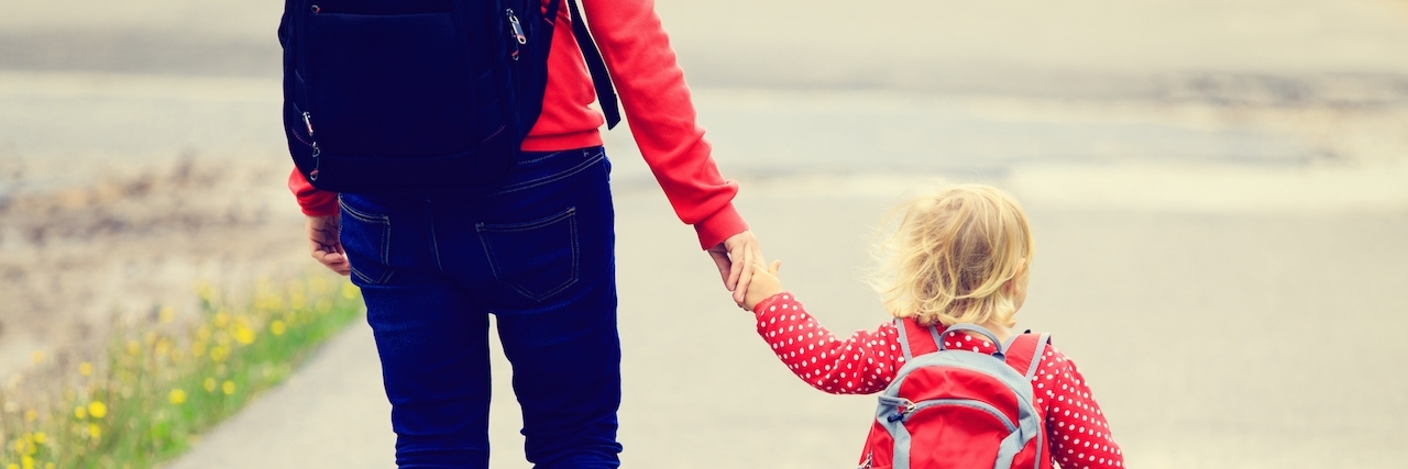 Why I Hide From Healthy Moms Because of My Illness Mother holding hand of little daughter with backpack going to school