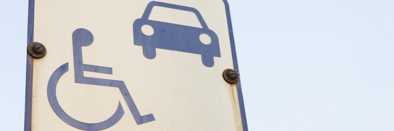 Parking in a Handicapped Space With Granulomatosis and Polyangiitis Disability symbol sign at car park