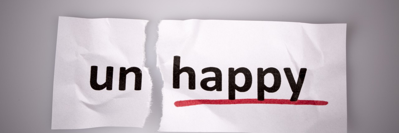 I Am Depressed, but I Feel Happiness The word unhappy changed to happy on torn paper and white background