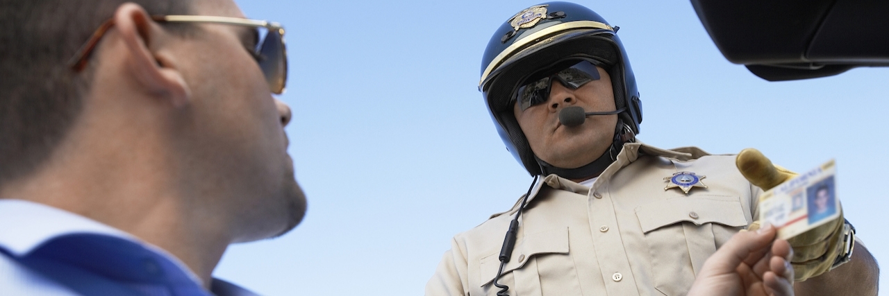 Sam Allen, Young Man With Autism, Campaigns for Notice on Driver's Licenses A man hands a police officer his driver's license.