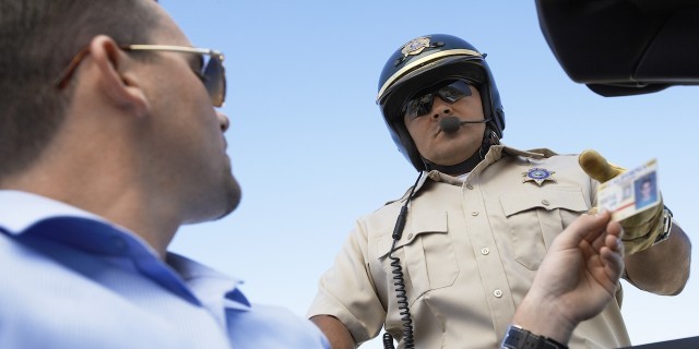 Sam Allen, Young Man With Autism, Campaigns for Notice on Driver's Licenses A man hands a police officer his driver's license.