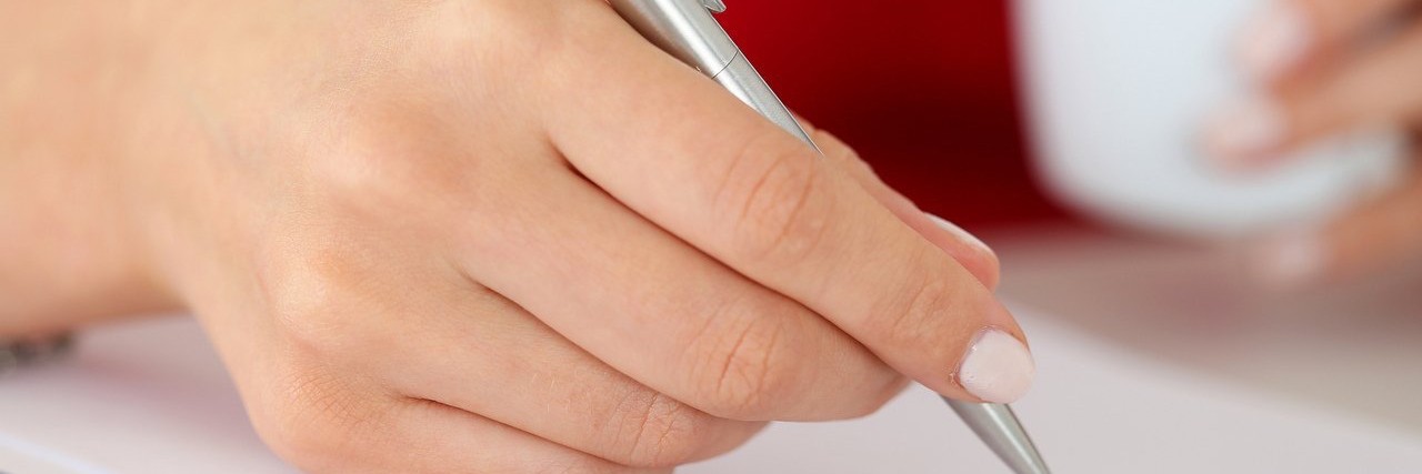 Dystonia: What My Chronic Pain Taught Me About Myself woman writing a letter