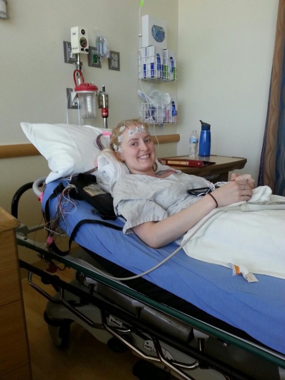 Angie lying on a bed in the hospital