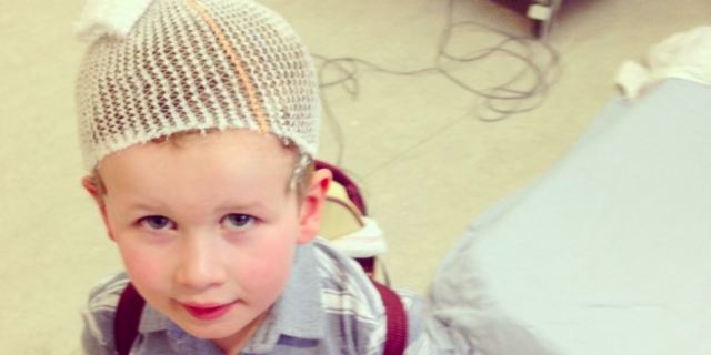 Young boy with mesh covering his hair and wires attached to head