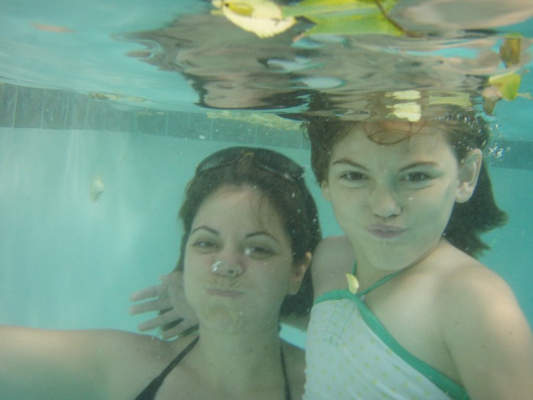 woman and little girl underwater in pool