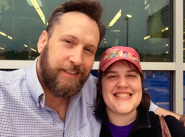 Chuck and Chrissy. Father and daughter are smiling. Chrissy wears a red baseball hat.