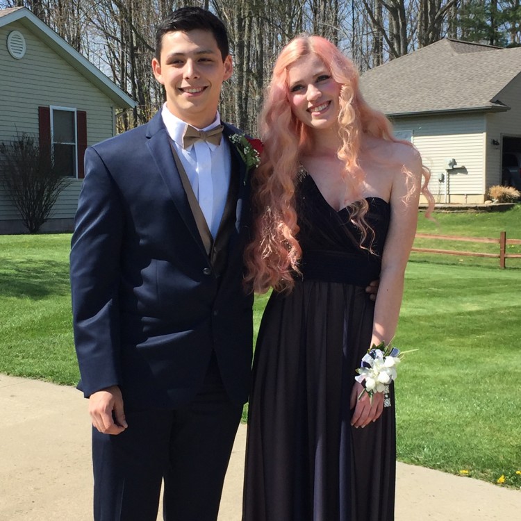 a girl and a boy posing dressed up for a dance