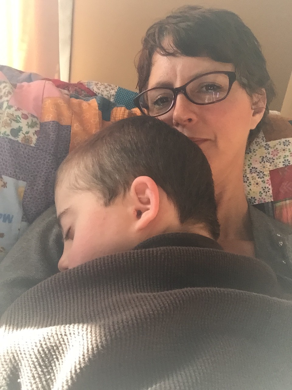 mom holding sleeping son