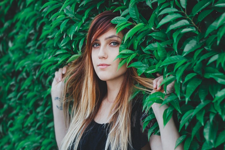 Ashley fanning hair out surrounded by leaves