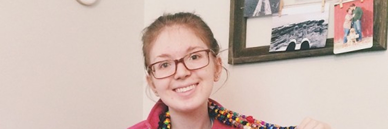 Raising Awareness for Ehlers-Danlos Syndrome in May girl sitting in chair holding up beaded necklace