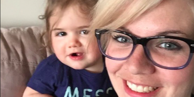 Contributor smiling with her daughter watching behind her