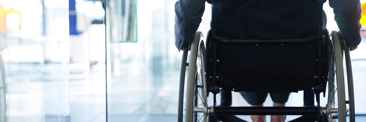 How I Learned to Accept Help When I'm Sick rear view of a businesswoman sitting in a wheelchair in an office