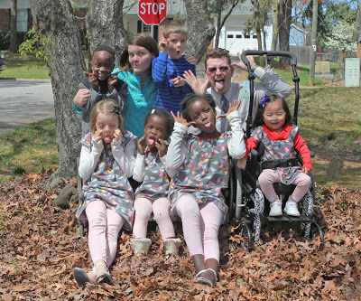 The author, her husband and her family posing outside, sitting in fall leaves. 