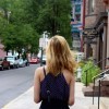The back of a woman's head standing on a side walk