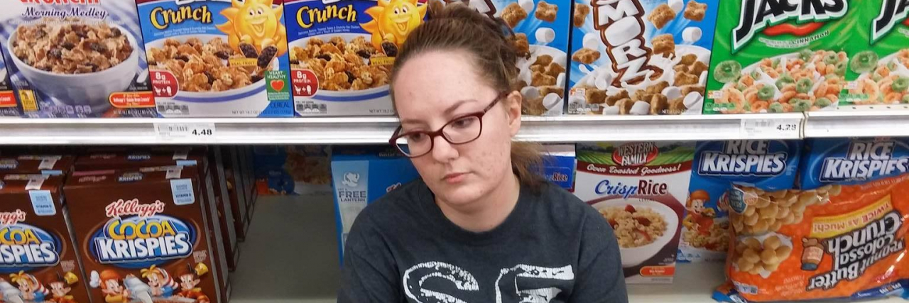 When Strangers Judge Me for Sitting Down in a Random Place girl sitting on floor of grocery store in cereal aisle