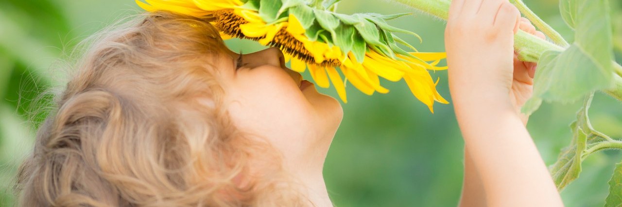 child smelling a flower