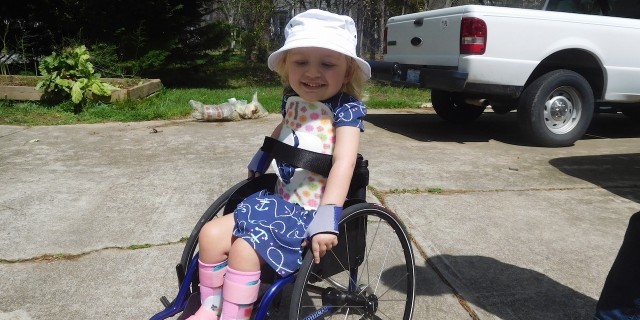 Heidi in her wheelchair smiling