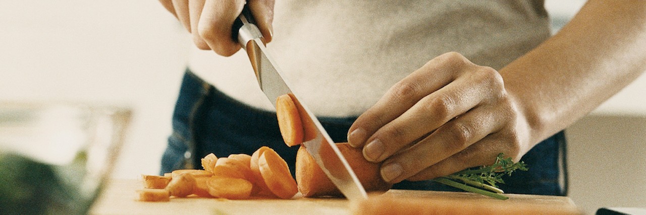 Person cuts carrots on cutting board