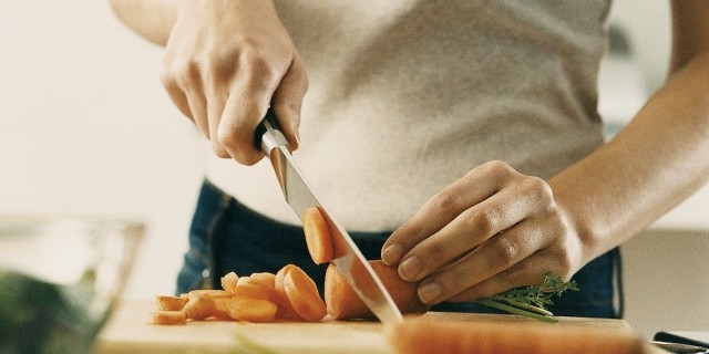 The Problem With the 'Clean Eating' Trend We Need to Address Person cuts carrots on cutting board