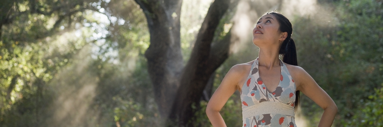 The Common Misconceptions Surrounding OCD Woman standing under trees looks up to the sun