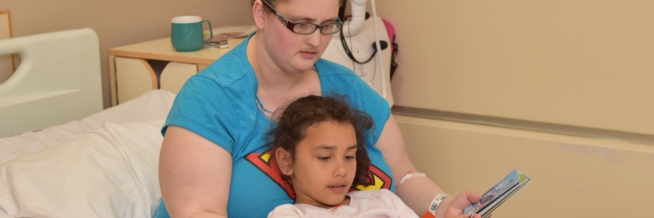 mom reading to her daughter in bed