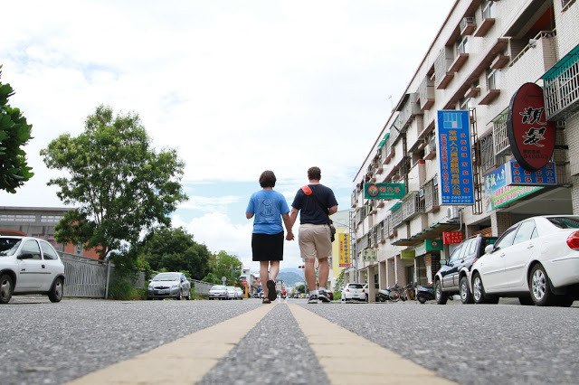 The author and her husband holding hands, walking down the street.