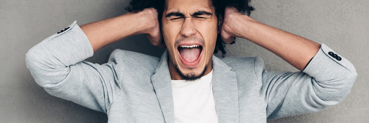 The Constant Presence of Depression Man covering ears and screaming