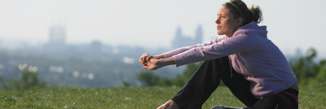 The Important of Listening to Anxiety Woman sitting on the grasses with city skyline in background