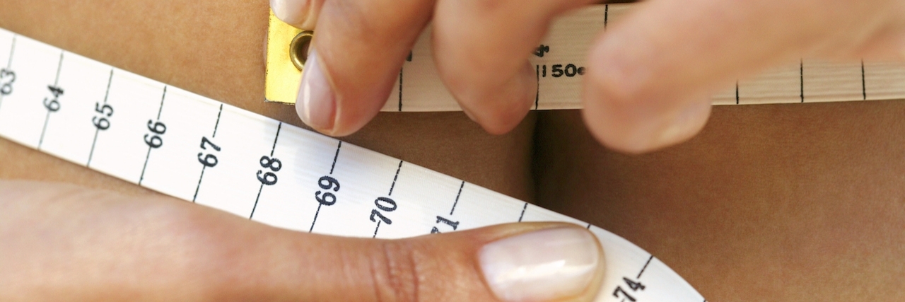 Woman measuring waistline