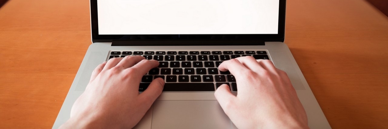 My Multiple Sclerosis Helped Me to Become a Writer Man using laptop computer in home interior.