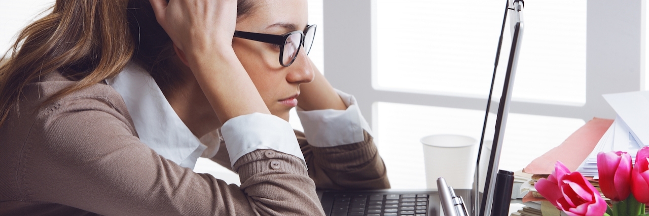 What's It's Like to Have ADHD as an Adult Woman stressed out sitting and staring at her laptop.