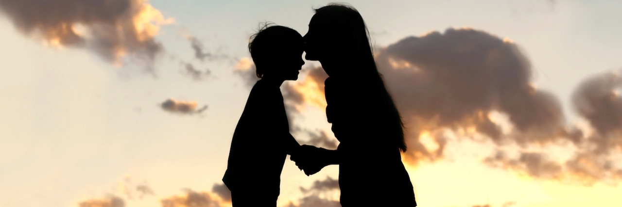 How a Raising a Child Helps With Depression Mom kisses little boy on the forehead