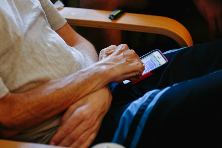 Ray's hands texting. The once-strong hands that delivered 2095 babies, held the handlebars of a bicycle for thousands of miles and created so many beautiful things have been reduced to one finger, with which Ray uses to communicate.