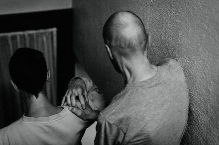 Ray and Rae walk down the stairs of their home, hand in hand.