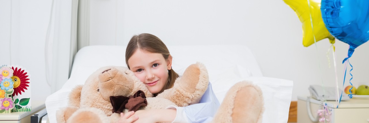How to Celebrate Birthdays When Your Child Is in the Hospital Child hugging a teddy bear in Hospital