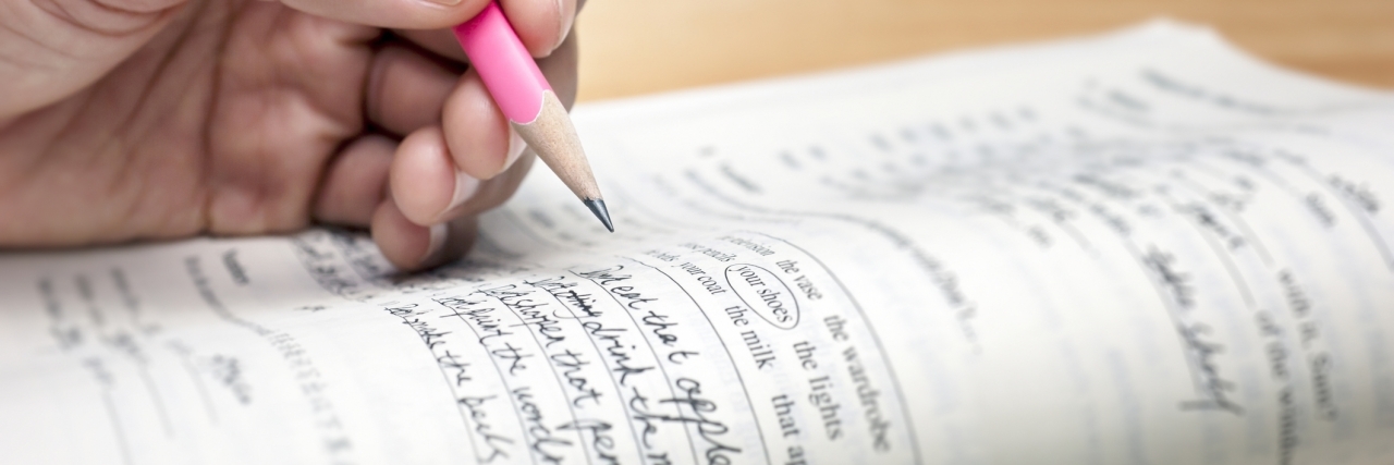 Teen Responds to 'Bipolar' Use on NY State Regents U.S. History Exam A closeup of a teenager holding a pencil while doing homework.