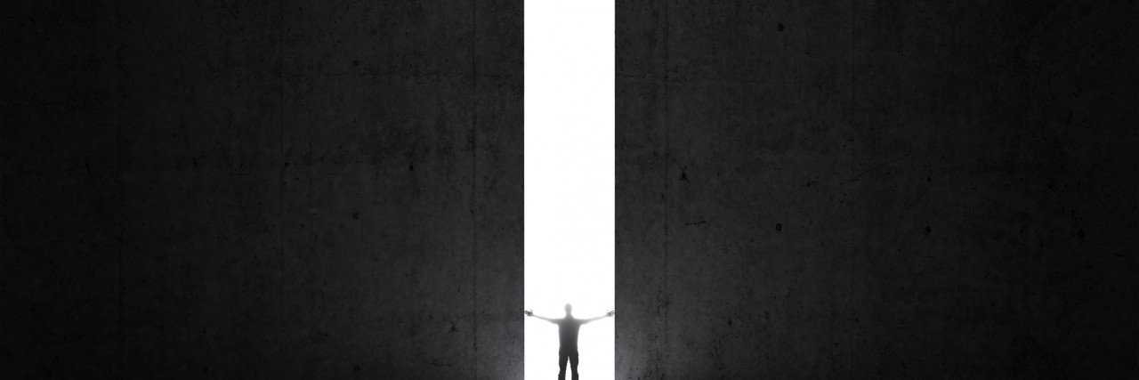 Dark abstract concrete interior. Man stands in the light of opening.