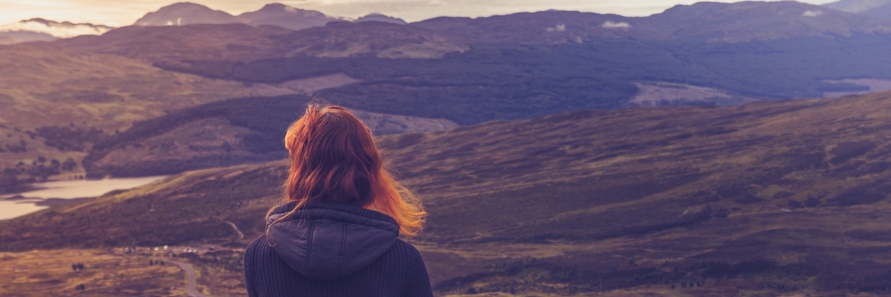 What You Can't See About My Depression and Anxiety Woman sitting on mountain top and contemplating the sunset