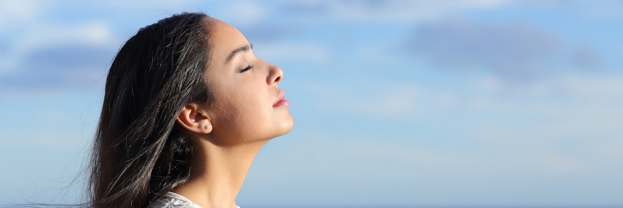 Advice for Living With Ehlers-Danlos Syndrome Profile of a beautiful arab woman breathing fresh air in the beach with a cloudy blue sky in the background